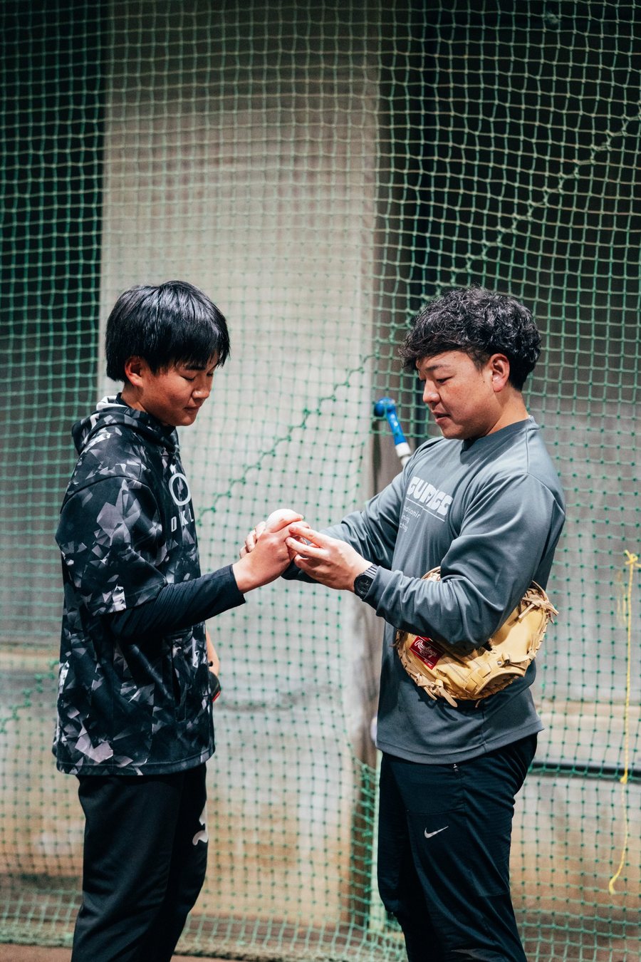 野球選手にボールの握りを指導する院長
