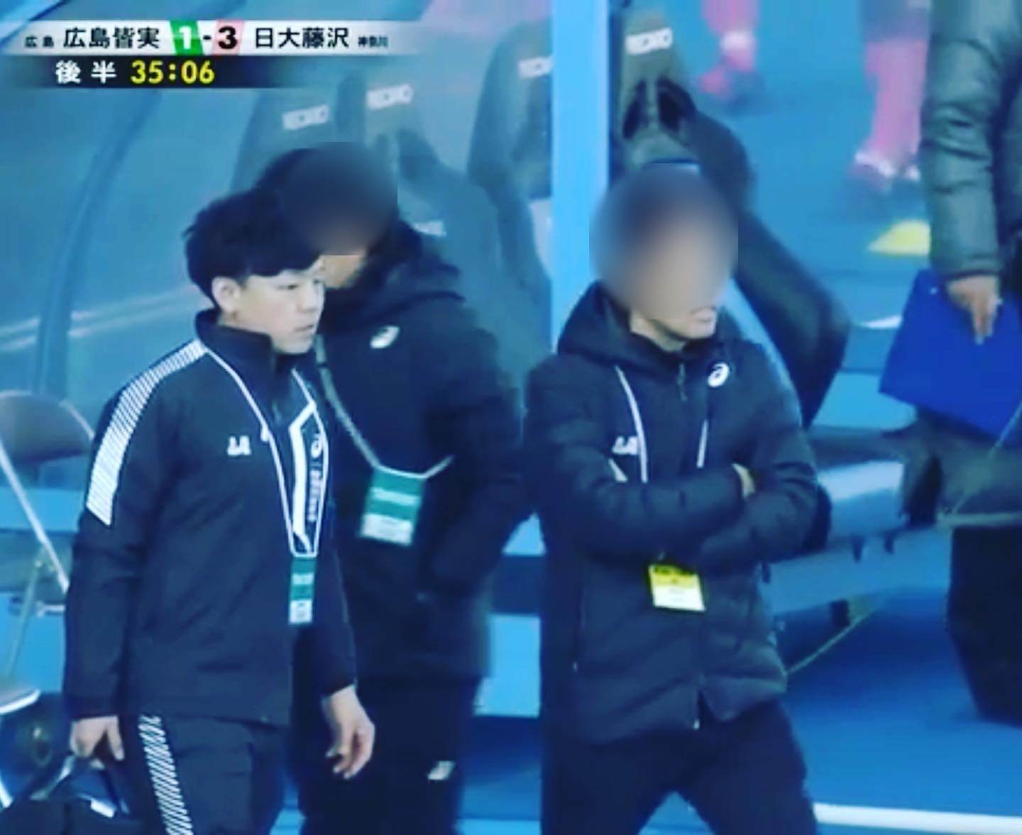 高校サッカーの試合でベンチに入る院長